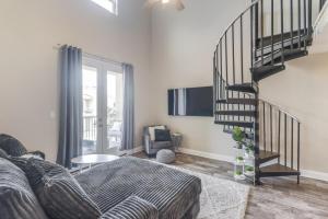 a living room with a couch and a spiral staircase at Poolside Paradise Condo in Long Beach