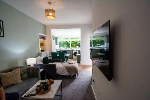 a living room with a couch and a tv at Modern apartment - sleeps 4 in Fife