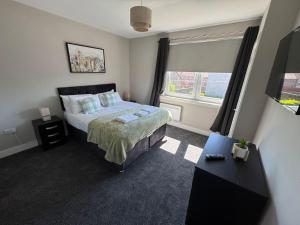a bedroom with a large bed and a window at 3 bedroom Falkirk flat in Falkirk