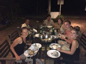 a group of people sitting around a table with food at Cashew Nut Bungalow, Ko Mook in Koh Mook