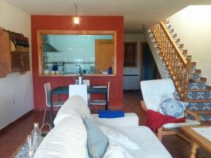 sala de estar con sofá blanco y escalera en Casa Rural Almanzor, en Navarredonda de Gredos