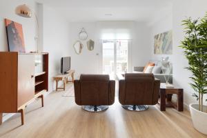 ein Wohnzimmer mit 2 Stühlen und einem TV in der Unterkunft Beach House 2 by FeelFree Rentals in San Sebastián