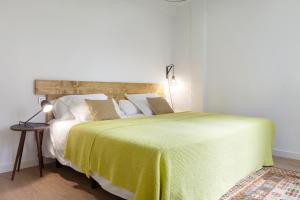ein Schlafzimmer mit einem großen Bett und einer gelben Decke in der Unterkunft Beach House 2 by FeelFree Rentals in San Sebastián