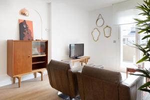 ein Wohnzimmer mit Stühlen und einem TV in der Unterkunft Beach House 2 by FeelFree Rentals in San Sebastián