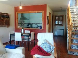 a living room with white chairs and a table at Casa Rural Almanzor in Navarredonda de Gredos
