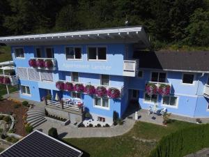 eine Luftaufnahme eines blauen Gebäudes mit Blumen in der Unterkunft Apartments in Flattach - Kärnten 50 in Flattach