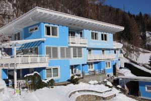 ein blaues Mehrfamilienhaus im Schnee in der Unterkunft Apartments in Flattach - Kärnten 50 in Flattach