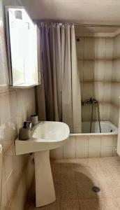 a white bathroom with a sink and a shower at Yiayias House in Limenaria +6 photos