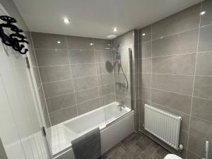 a bathroom with a shower and a bath tub at Lower Townhouse, Exeter in Alphington