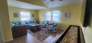 Una sala de estar con un sofá y sillas y un televisor. en Tipsy Turtle - relax, unwind, you're on turtle time, en Port Aransas