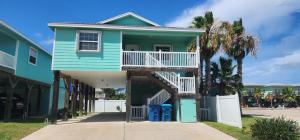 una casa azul con una escalera frente a una calle en Tipsy Turtle - relax, unwind, you're on turtle time, en Port Aransas