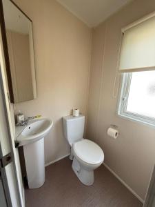 a bathroom with a white toilet and a sink at Luxury 2 bedroom Caravan Pets stay Free in Hunstanton +15 photos