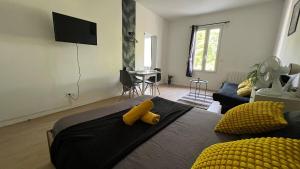 ein Schlafzimmer mit einem Bett mit einem gelben Objekt darauf in der Unterkunft Studio Bali I spacieux avec jardin d'été I proche Futuroscope in Châtellerault