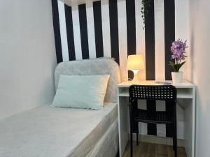 a bed with a desk with a pillow and a chair at Simple Stay Partition Room In Barsha heights Tecom in Dubai