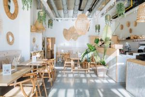 a restaurant with wooden tables and chairs and plants at Sweet Coffee Stay Apartments in Hasselt