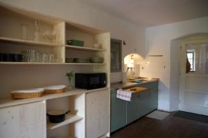 a kitchen with white walls and a blue cabinet at Vintage Lake House Bohinj in Bohinj +13 photos