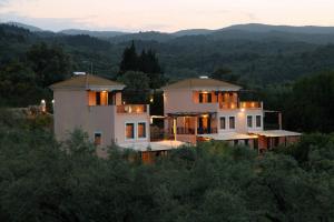 a large white house on top of a hill at Orizzonte Apartments Lefkada in Lefkada