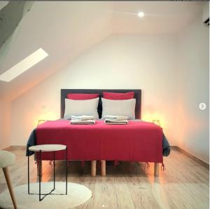 a bedroom with a red bed with two pillows at Le 4 in Montignac