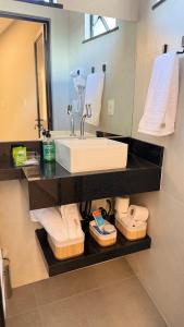 une salle de bain avec un lavabo, un miroir et des serviettes dans l'établissement Loft incrível, Novo, Centro,Design exclusivo, à Santo Antônio de Jesus