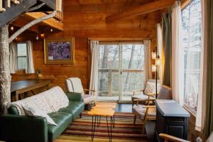 RogersにあるThe Cliffside Cabin - Stunning Views in Red River Gorgeのリビングルーム(緑のソファ、窓付)