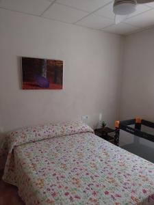 a bedroom with a bed and a painting on the wall at VENTA PURA in Águilas