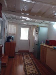 a kitchen with a refrigerator and a window and a door at Costi&Miha in Botoşani
