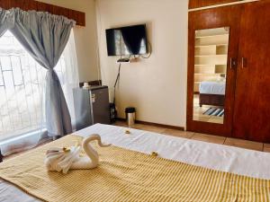 een zwanenhanddoek op een bed in een slaapkamer bij KwaDines Guesthouse in Standerton