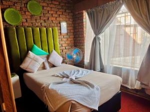 een slaapkamer met een bed met een strik erop bij KwaDines Guesthouse in Standerton +76 foto's