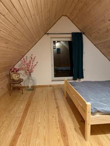 a bedroom with a bed and a window in a room at Agroturystyka u Smerfa in Ugoszcz
