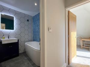 a bathroom with a tub and a sink at Historic Hampshire Cottage with Private Putting Green in Eversley +34 photos