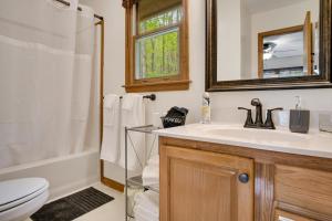 a bathroom with a sink and a toilet and a mirror at Elk Ridge Retreat -Hot Tub- Firepit-Fireplace in Maggie Valley +34 photos