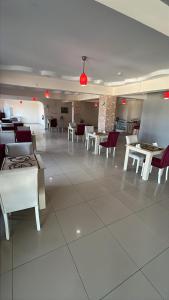 a dining room with white tables and white chairs at Grand Alver Otel in Edremit