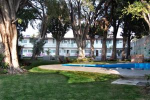 a building with trees and a pool in a park at Casa Sta Inés in Cuautla Morelos