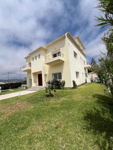 a large white house with a grass yard at Villa Belle Rive Estate in Oulad Akkou +17 photos