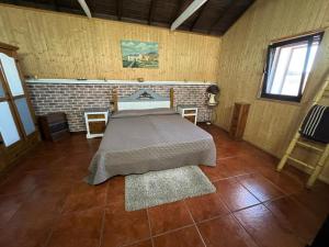 a bedroom with a bed and a brick wall at Casa La Gollada in Cazadores +68 photos