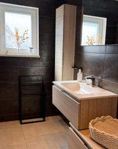 a bathroom with a sink and a mirror at Au Jardin Secret in Rimsdorf