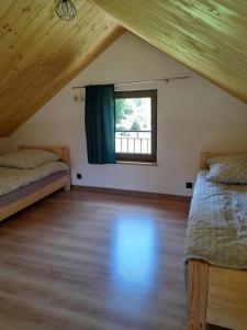 two beds in a room with a window at Przystanek Bereżnica in Bereżnica Wyżna