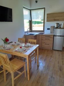 a kitchen with a wooden table with chairs and a sink at Przystanek Bereżnica in Bereżnica Wyżna