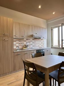 a kitchen with a wooden table with chairs and a table and a table at Bilocale31 - stile e comfort a Frascineto in Frascineto