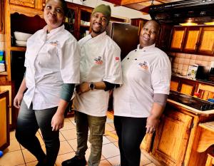 een groep van drie koks in een keuken bij KwaDines Guesthouse in Standerton