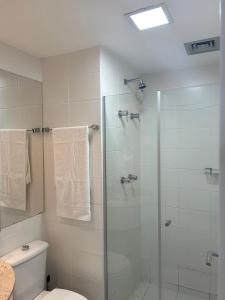 a bathroom with a glass shower with a toilet at Fusion e Vision Flats in Brasilia