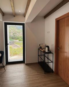 a room with a large window and a table with a phone at Cottage - A Casa da Avó in São Vicente