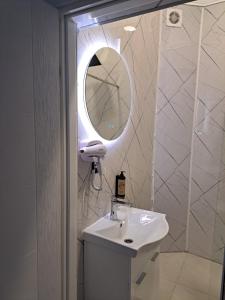 a white bathroom with a sink and a mirror at NEW - Old Town Pearl Apartments in Sarajevo