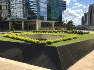 a building with a garden in front of it at Fusion e Vision Flats in Brasília