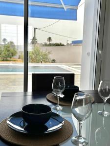 a table with two wine glasses and a black bowl and sidx sidx sidx at Villa Olivia in El Guecheïne