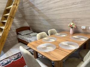 a wooden table with four plates on it in a room at Miman house Kolsay in Kurmenty
