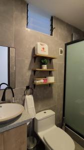 a bathroom with a white toilet and a sink at La Casita De Colores Cusco in Cusco +26 photos
