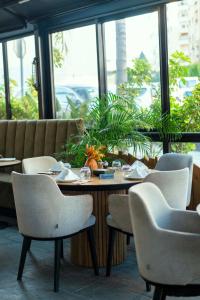 a dining room with a table and chairs and windows at Flamant Rose Appart Hotel in Tangier