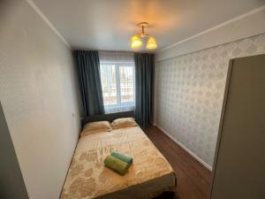 een kleine slaapkamer met een bed en een raam bij LuxHome на УК in Öskemen +25 foto's