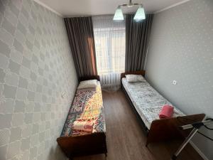 een slaapkamer met twee bedden en een raam bij LuxHome на УК in Öskemen